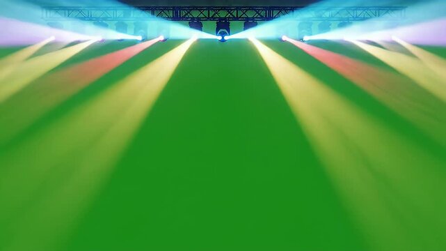 A row of stage lights projects vibrant beams of pink, blue, and white onto a bright green background, creating a dynamic and theatrical atmosphere.