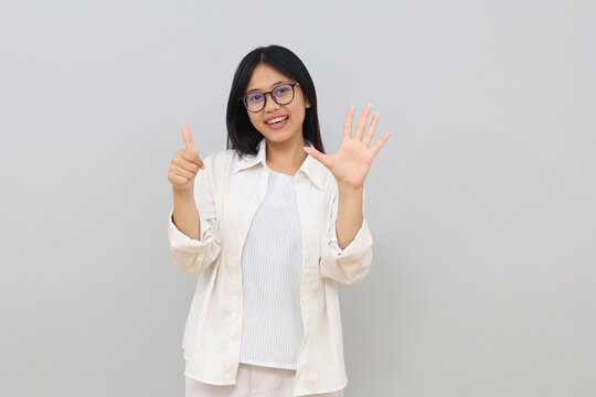 Happy and beautiful Asian girl smiling, showing six fingers to explain the rules and steps, standing on a white background.