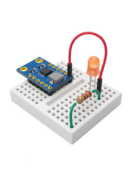 Close-up shot of electronic components on a breadboard, including a circuit board and an LED light, ideal for technology and electronics projects