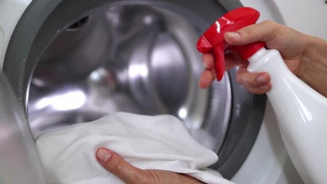 Applying stain remover to laundry before washing. Concept fabric care, household chores and cleaning routine.

