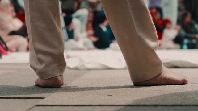 Bare feet of an Indian man praying during the Holi festival