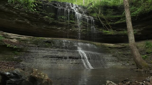 Wide View of Stillhouse Hollow Falls With Rain Drops Falling Into a Forest Pool