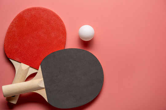 Ping pong rackets and balls on pink background, flat lay