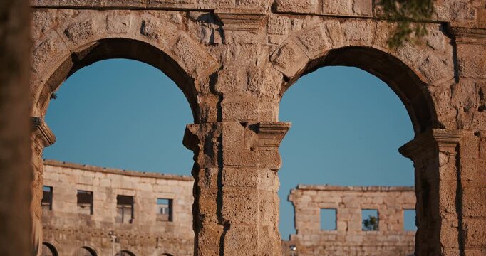 View of stone arches and columns inside the ancient Pula Arena Roman amphitheater in Pula Croatia.