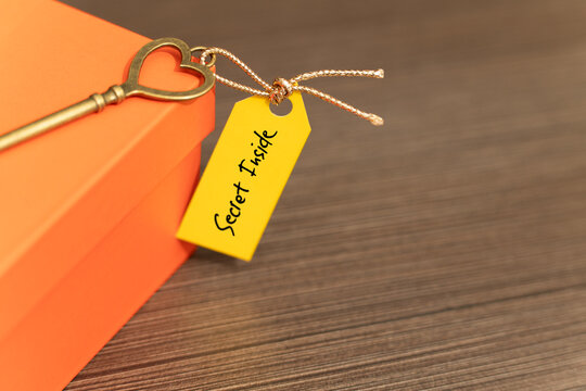 Secret inside gift box concept with heart shaped key and hidden message tag on box