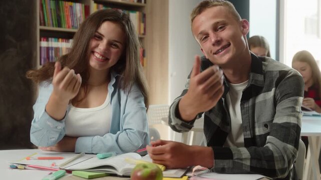 Happy Caucasian hight school students girl boy guywaving hand inside classroom welcome gesture smiling schoolgirl schoolboy teenagers greeting invite studying learning together education university