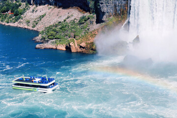 Fototapeta premium Tour boat approaching misty Niagara Falls rainbow