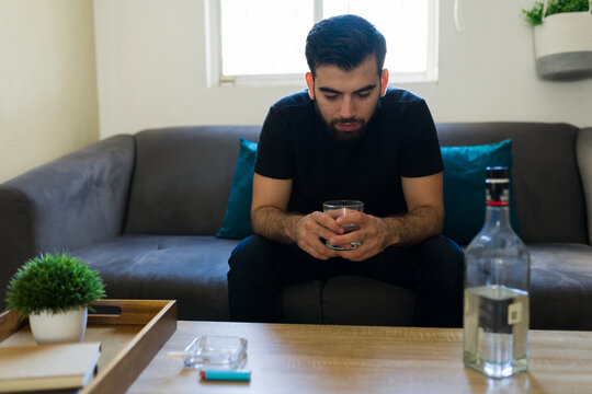 Man feeling sad and lonely, using alcohol to cope with personal problems. Addiction and mental health struggles
