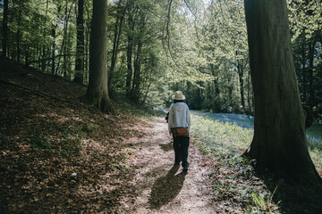 Fototapeta premium A couple of young people are walking along a path among the trees in the forest.