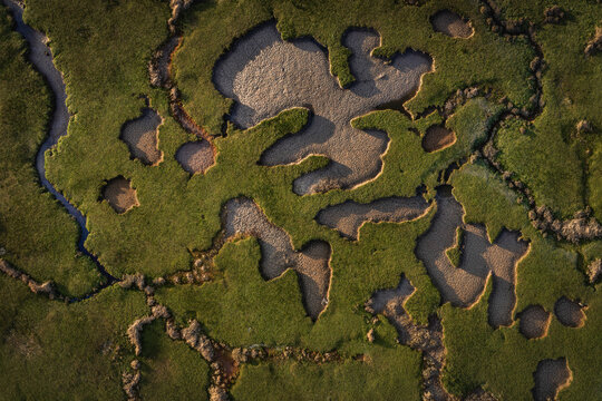 Aerial view of the abstract patterns of salt marshes and sandy patches at Portmarnock Beach in County Dublin, Ireland.