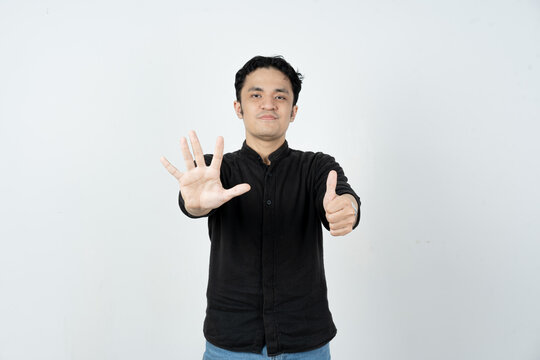 Young Asian man showing six fingers counting gesture on white background