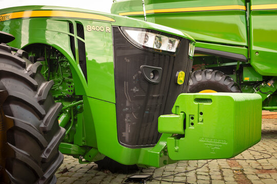 Front view of a John Deere 8400R highlighting counterweight ballast, cooling grille, light assembly, and high-traction tires.