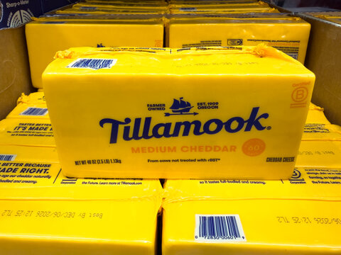 Prosper, Texas, USA - May 06th, 2026: Tillamook medium cheddar cheese blocks in yellow packaging stacked in carton at local Costco retail warehouse
