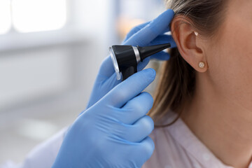 Hearing test. Doctor examining woman's ear with otoscope in clinic, closeup. Space for text © New Africa
