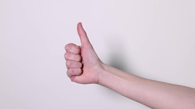 Woman showing thumbs up on grey background, closeup