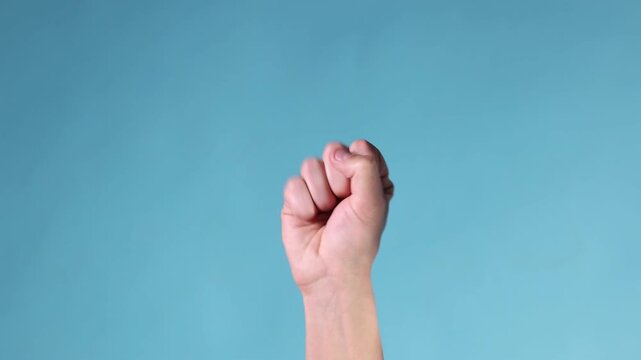Man counting on fingers against light blue background, closeup