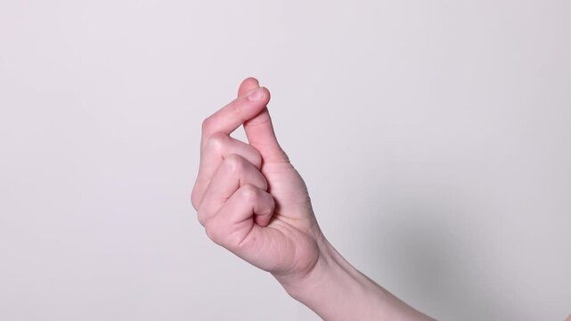 Woman showing heart gesture with fingers on grey background, closeup