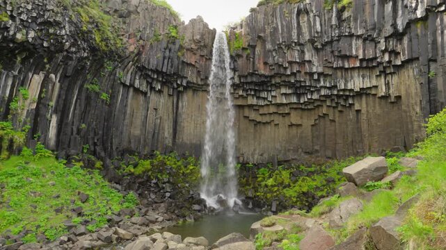 Famous and beautiful Svartifoss waterfall on a summer day in south Iceland. Located in Skaftafell in Vatnaj&ouml;kull National Park. Surrounded by dark lava columns and sharp rocks.