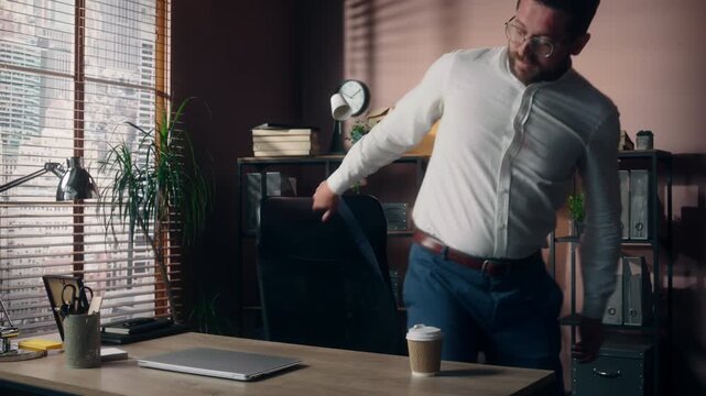 Successful Caucasian business man starting work day in office drinking coffee typing laptop male entrepreneur programmer businessman stretching project investment manager employer worker computer desk