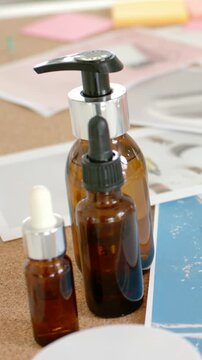 Vertical video: Shifting camera tilting right, revealing three amber bottles with blue sheet