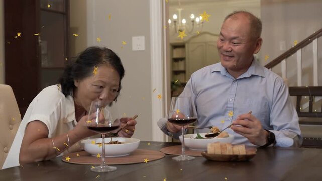 Mature couple dining woman leaning eating sitting back man sipping wine gold stars passing in front