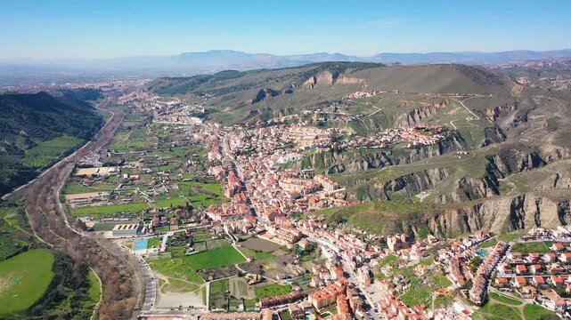 Aerial 4K video from a drone to Granada on a sunny day. In the background, the green mountains of Granada. Granada, Sierra Nevada, Andalusia, Spain.