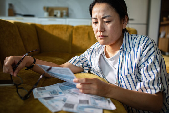 Worried woman reviewing household bills at home