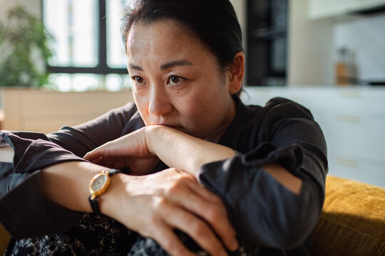Pensive middle-aged woman at home