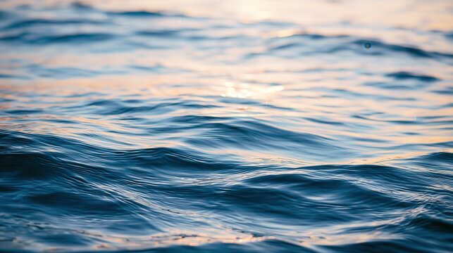 Calm ocean waves gently ripple under a soft sunset sky, reflecting warm pink and blue hues.