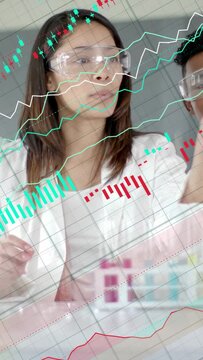 Vertical video: Lab tech speaking initiating lifting studying vial while finance charts overlaying