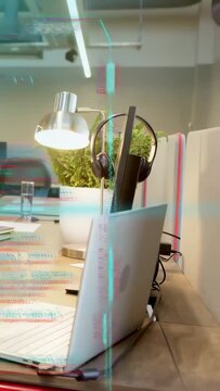 Vertical video: Glitch starting laptop and stand shifting as HUD and code overlaying desk as noise