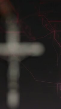 Vertical video: Hand placing rosary starting focus pull, crucifix coming into focus for close shot