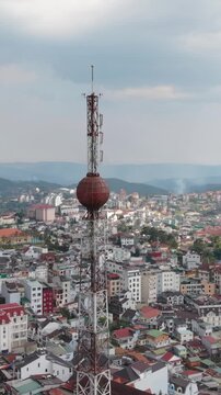 Vertical screen, Vietnam, Da Lat Aerial Dalat Rooftops Tower, High Viewpoint Capturing Colorful Tile Patterns, Tight Urban Grid, Telecom Sphere, Soft Distant Hills And Contemplative
