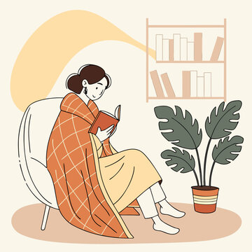 Woman reading a book wrapped in a blanket near a plant on a cozy day indoors