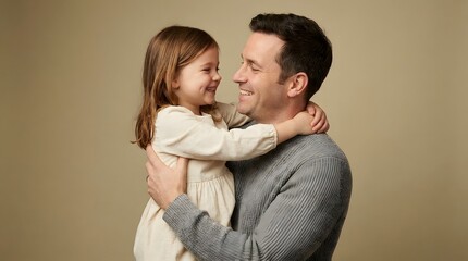 Fototapeta premium Smiling father and daughter embracing with love and affection against a neutral background