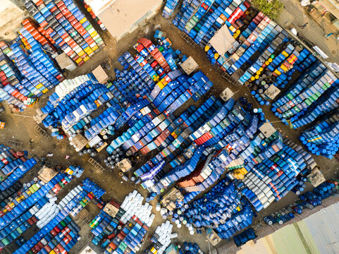 Aerial view of thousands of colorful plastic barrels and industrial drums stacked in an outdoor storage yard Dhaka, Dhaka Division, Bangladesh.