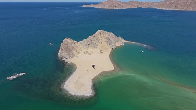 Watch an SUV with a teardrop trailer parked on a remote island in Punta Final while enjoying the beauty of Gonzaga Bay, Mexico.