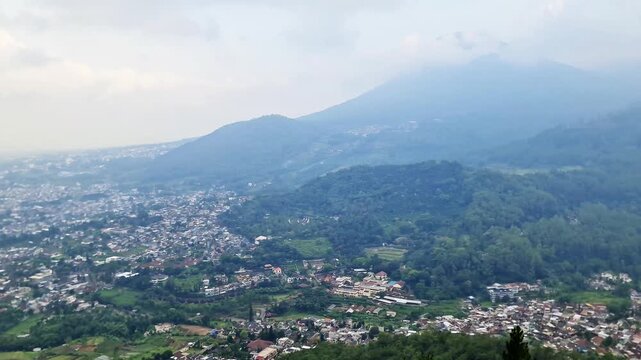 Highland Summit Panorama with Villages, City Valley, and Rolling Hills Beneath Cloudy Sky