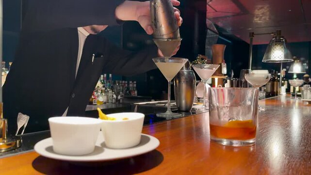 Professional Japanese Bartender Straining a Cocktail into a Martini Glass