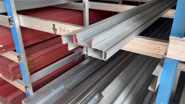 Lightweight steel roof truss profiles stacked on warehouse shelves