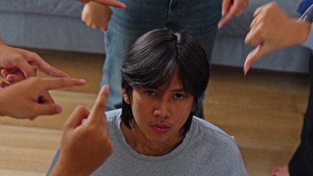 Young man being judged and accused by group illustrating social pressure, harassment, and bullying