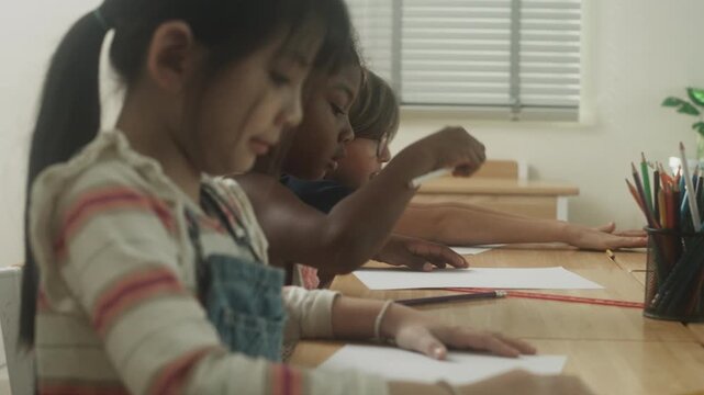 Children engaged in creative learning and drawing activity together inside classroom environment.