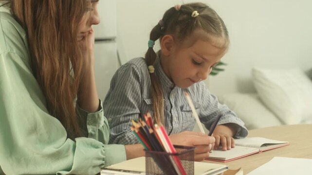Child learning and practicing educational activity at home with support from parent in comfortable indoor environment.