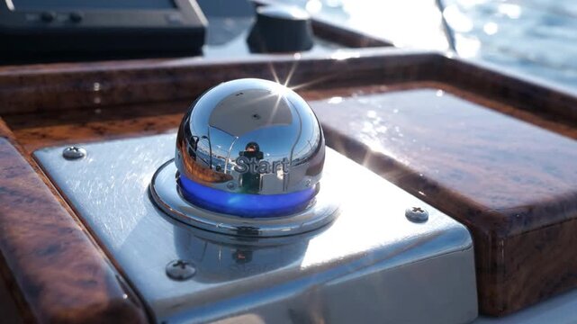 Polished chrome button start boat helm with led reflection sunlight sparkle wood dash detail shiny chrome engine start button wooden boat dashboard reflecting sea breeze nautical control detail