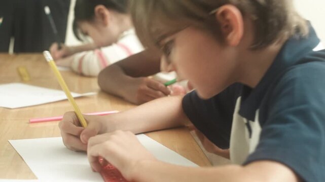 Children engaged in creative learning and drawing activity together inside classroom environment.