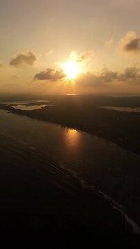 Drone ascends and pulls back over sunset-lit water near Bodden Town on Grand Cayman&rsquo;s south coast
