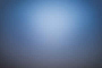 Obraz premium Professional blue gradient background with soft central light. Smooth texture and elegant vignette, ideal for corporate presentations, studio portraits, and modern digital wallpapers.