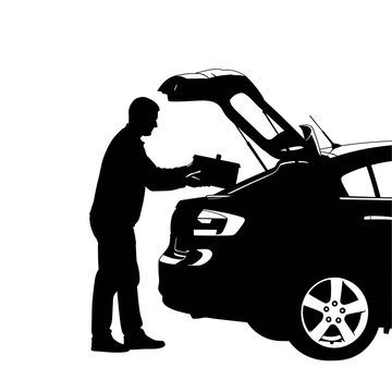 Silhouette of a man loading a suitcase into the open trunk of a car, preparing for a travel journey or road trip.