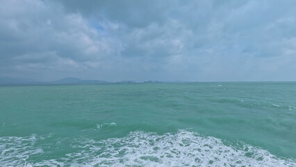 Obraz premium Turquoise Ocean Waves Under a Cloudy Sky Near Koh Samui Thailand