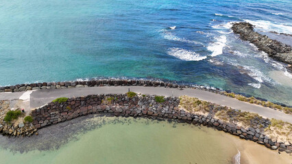 Naklejka premium Aerial View of a Rocky Breakwater and Turquoise Ocean in Apollo Bay